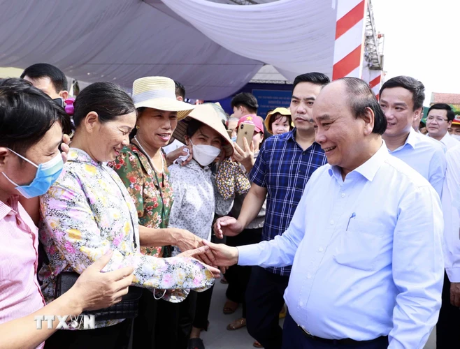 Chủ tịch nước Nguyễn Xuân Phúc thăm hỏi các hội viên Hợp tác xã Tân Minh Đức. (Ảnh: Thống Nhất/TTXVN)