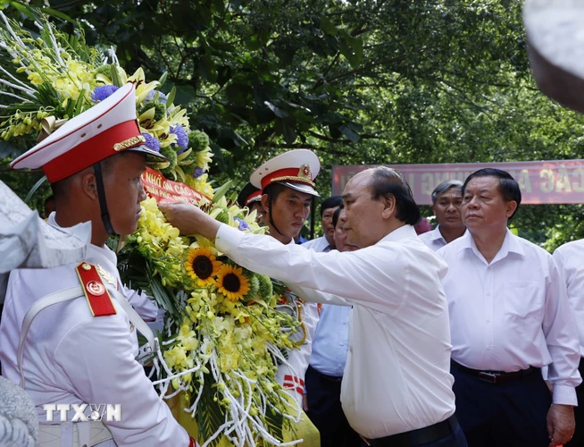 Chủ tịch nước Nguyễn Xuân Phúc dâng hoa tại Đền thờ Liệt sỹ Hang 8 thanh niên xung phong. (Ảnh: Thống Nhất/TTXVN)