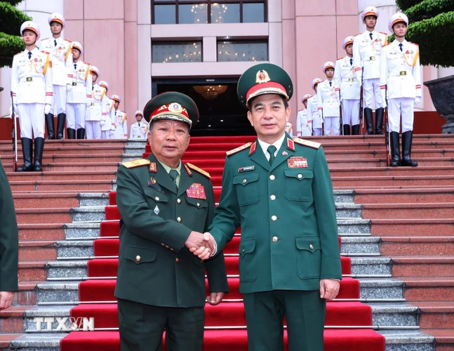 Bộ trưởng Bộ Quốc phòng Phan Văn Giang và Phó Thủ tướng, Bộ trưởng Quốc phòng Lào Chansamon Chanylath tại lễ đón. (Ảnh: Trọng Đức/TTXVN)