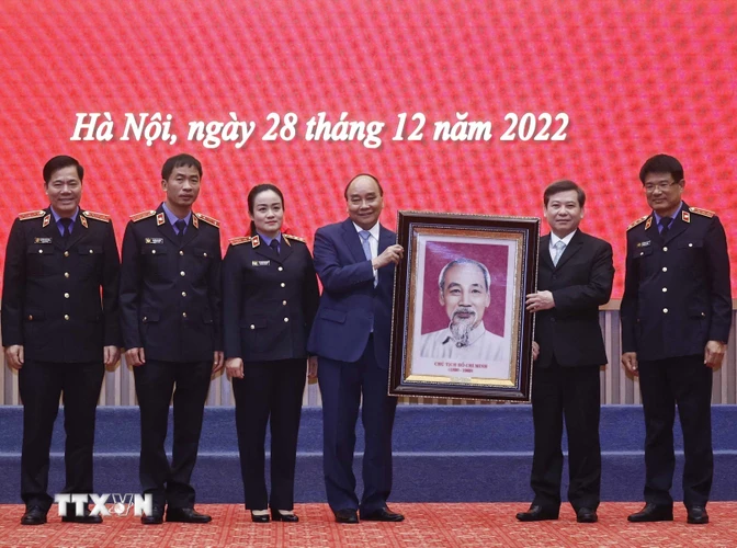 Chủ tịch nước Nguyễn Xuân Phúc trao bức chân dung Chủ tịch Hồ Chí Minh tặng ngành kiểm sát nhân dân. (Ảnh: Thống Nhất/TTXVN)
