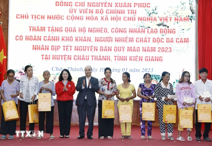 Chủ tịch nước Nguyễn Xuân Phúc tặng quà cho hộ nghèo, công nhân lao động có hoàn cảnh khó khăn, người nhiễm chất độc da cam trên địa bàn. (Ảnh: Thống Nhất/TTXVN)