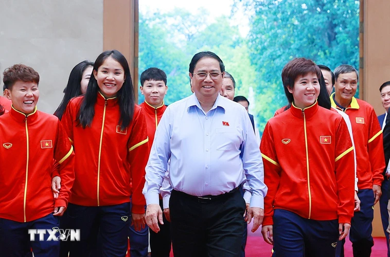 Thủ tướng Phạm Minh Chính với các cầu thủ Đội tuyển Bóng đá Nữ Quốc gia Việt Nam. (Ảnh: Dương Giang/TTXVN)