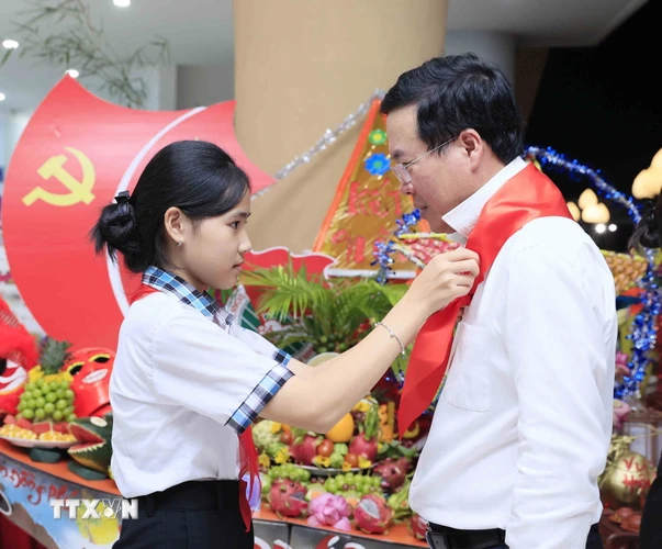Thiếu nhi tỉnh Bình Phước đeo khăn quàng đỏ cho Chủ tịch nước Võ Văn Thưởng. (Ảnh: An Đăng/TTXVN)