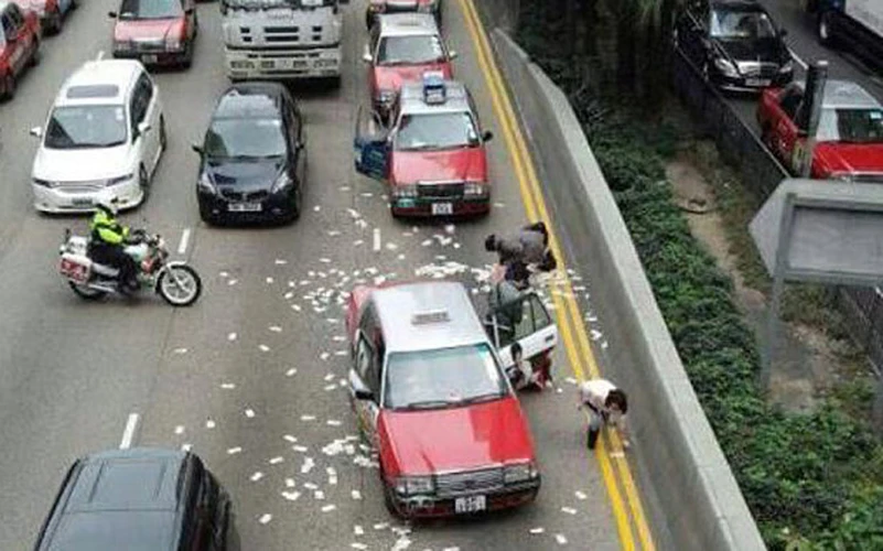 Hàng chục lái xe và người đi đường vội vàng đổ xô đến nhặt khiến giao thông trở nên hỗn loạn. (Nguồn: South China Morning Post)