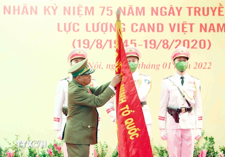 Đại tướng Vilay Lakhamphong, Bộ trưởng Bộ Công an nước Cộng hòa Dân chủ Nhân dân Lào gắn Huân chương Tự do hạng Nhất của Nhà nước CHDCND Lào lên lá cờ truyền thống của Bộ Công an nước CHXHCN Việt Nam. (Ảnh: Phạm Kiên/TTXVN)