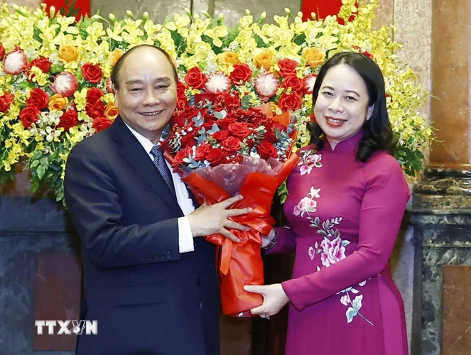 Quyền Chủ tịch nước Võ Thị Ánh Xuân tặng hoa nguyên Chủ tịch nước Nguyễn Xuân Phúc. (Ảnh: Thống Nhất/TTXVN)