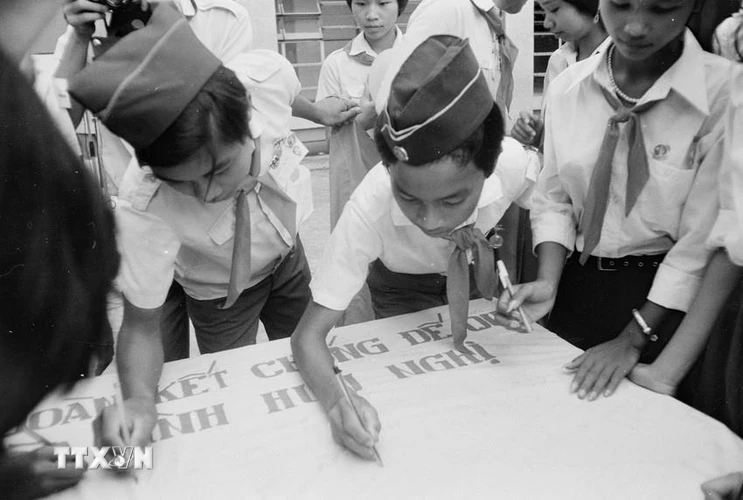 Các đại biểu thiếu nhi dự Đại hội Cháu ngoan Bác Hồ toàn quốc lần thứ II ký tên vào lá cờ hòa bình trong hoạt động vì hòa bình tại Cung Thiếu nhi Hà Nội (6/7/1986). (Ảnh: Trần Ấm/TTXVN)