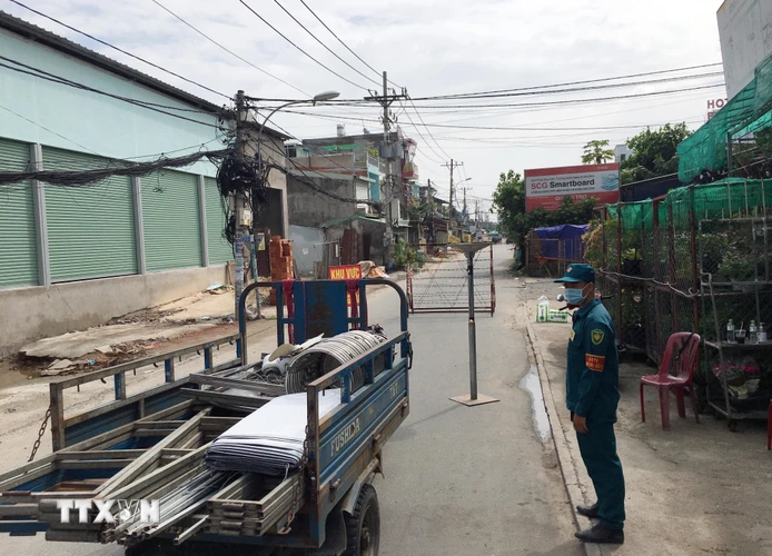 Lực lượng chức năng chốt chặn đầu đường TL19, đoạn giao đường Hà Huy Giáp (phường Thạnh Lộc, Quận 12, Thành phố Hồ Chí Minh). (Ảnh: Tiến Lực/TTXVN)