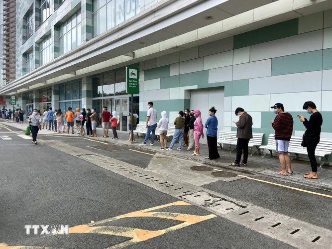 Người dân xếp hàng dài tại Trung tâm thương mại Aeon Mall Tân Phú (quận Tân Phú, Thành phố Hồ Chí Minh) chờ vào mua sắm sau thông tin siết chặt giãn cách xã hội. (Ảnh: Mạnh Linh/TTXVN)