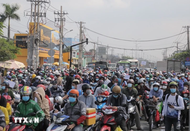 Hàng nghìn người dân tập trung ở khu vực Quốc lộ 1 đoạn qua Thị trấn Tân Túc, huyện Bình Chánh, Thành phố Hồ Chí Minh. (Ảnh: TTXVN phát)