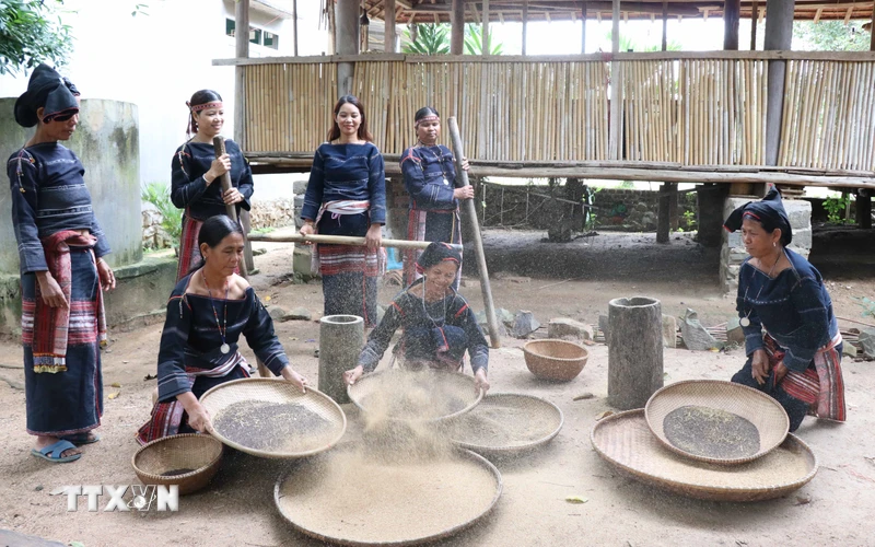 Phụ nữ trong làng tập trung giã, sàng sẩy để lựa chọn hạt Cào đạt chuẩn nấu rượu cần. (Ảnh: Hồng Điệp/TTXVN)