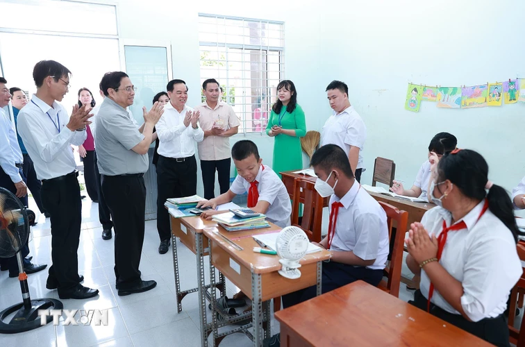 Thủ tướng Phạm Minh Chính thăm, động viên học sinh Trường nuôi dạy trẻ em khuyết tật Bến Tre. (Ảnh: Dương Giang/TTXVN)