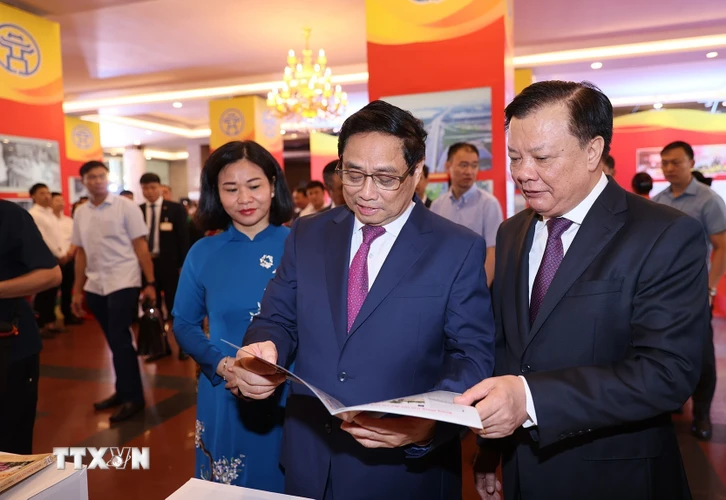 Thủ tướng Phạm Minh Chính cùng các đại biểu tham quan trưng bày sách Những bông hoa đẹp. (Ảnh: Dương Giang/TTXVN)