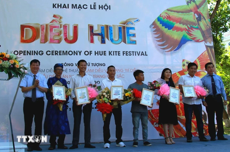 Ban tổ chức trao giấy chứng nhận cho nghệ nhân và nhà tài trợ tham gia lễ hội Diều Huế. (Ảnh: Tường Vi/TTXVN)