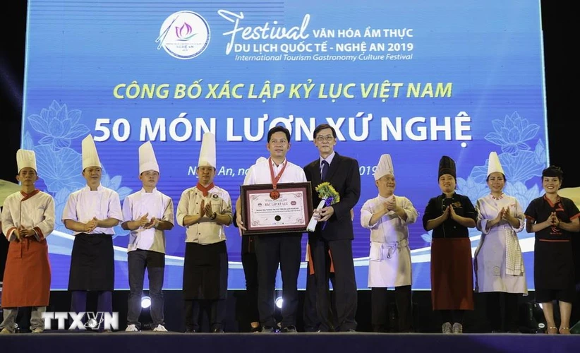 Ban tổ chức trao bằng xác lập kỷ lục Việt Nam 50 món lươn xứ Nghệ. (Ảnh: Bích Huệ/TTXVN)