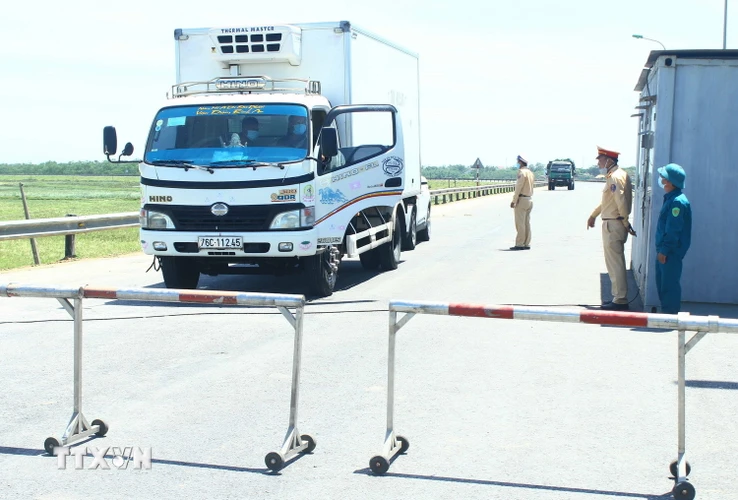  Cán bộ chiến sỹ Cảnh sát giao thông thành phố Vinh "căng mình" dưới nắng nóng để giải thích cho các phương tiện không được qua chốt kiểm soát tại đê xã Hưng Hòa, thành phố Vinh, tỉnh Nghệ An khi không đầy đủ các giấy tờ theo quy định. (Ảnh: Tá Chuyên/TTXVN)