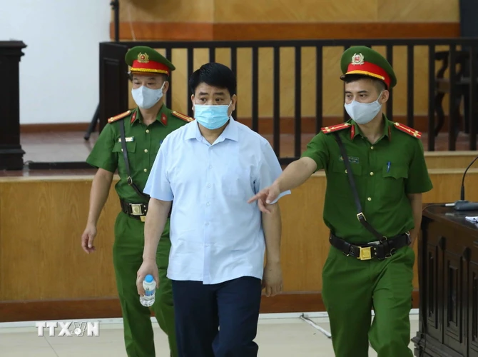 Lực lượng chức năng dẫn giải bị cáo Nguyễn Đức Chung tới phiên tòa phúc thẩm. (Ảnh: Phạm Kiên/TTXVN)