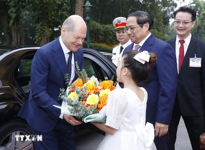 Thiếu nhi Hà Nội tặng hoa, chào mừng Thủ tướng Đức Olaf Scholz. (Ảnh: TTXVN)