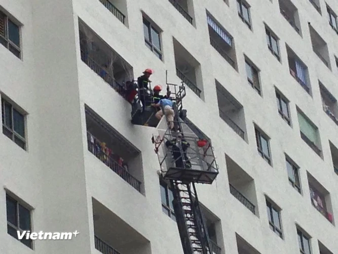 Xe thang của cảnh sát phòng cháy chữa cháy giải cứu người bị mắc kẹt trong tòa nhà HH4. (Ảnh: Sơn Bách/Vietnam+)