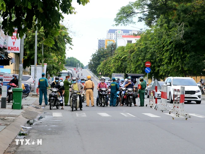 Nhiều người dân lưu thông qua chốt kiểm soát trên đường Nguyễn Thái Sơn (quận Gò Vấp) sáng 13/8 không có lý do theo quy định, được yêu cầu quay về nhà. (Ảnh: Thành Chung/TTXVN)