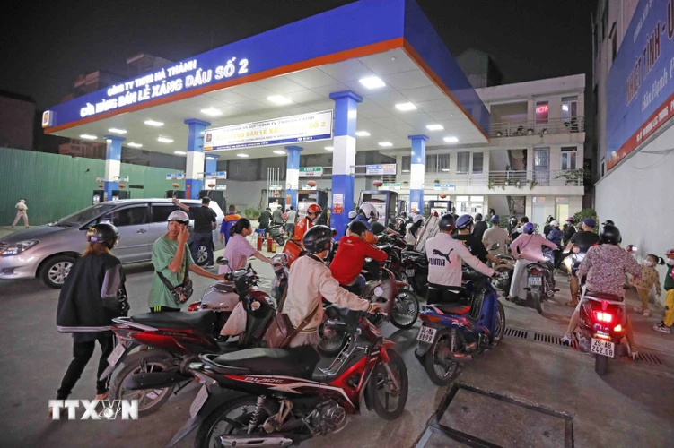 Người dân xếp hàng dài chờ mua xăng, dầu tại cửa hàng kinh doanh xăng, dầu trên phố Lạc Trung, tối 5/11. (Ảnh: Trần Việt/TTXVN)
