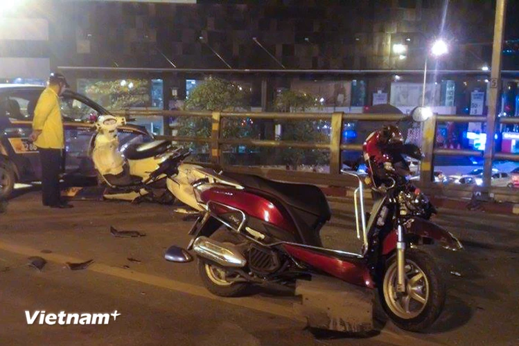 Khoảng 22h40 phút ngày 8/10, chiếc taxi của hãng Vinataxi di chuyển trên cầu vượt nút giao thông Chùa Bộc - Thái Hà bất ngờ mất lái và tông trực diện hàng chục xe máy đang lưu thông. (Ảnh: Minh Sơn/Vietnam+)