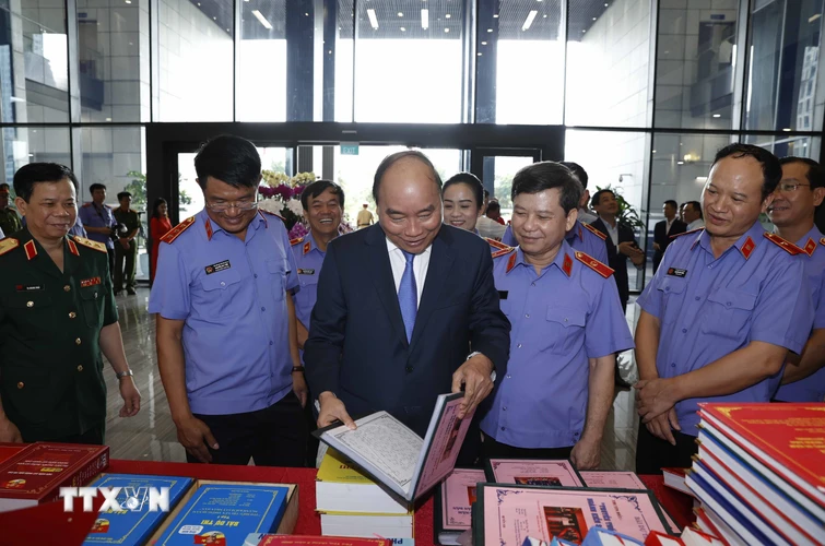 Thủ tướng Nguyễn Xuân Phúc và đại biểu xem các tác phẩm được giải về ngành Kiểm sát. (Ảnh: Thống Nhất/TTXVN)