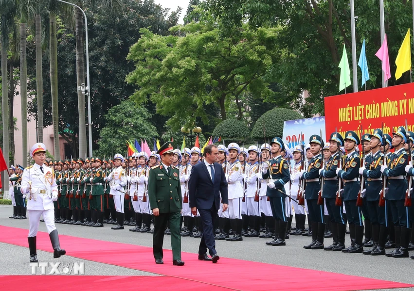 Bộ trưởng Quốc phòng Phan Văn Giang và Bộ trưởng Quân đội Pháp Sébastien Lecornu duyệt Đội danh dự Quân đội Nhân dân Việt Nam tại lễ đón. (Ảnh: Trọng Đức/TTXVN)