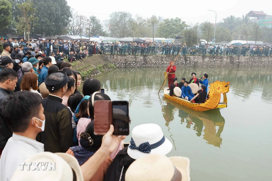Người dân và du khách các nơi nô nức kéo về làng Diềm xem biểu diễn hát Quan họ trên thuyền. (Ảnh: Đoàn Công Vũ/TTXVN phát)