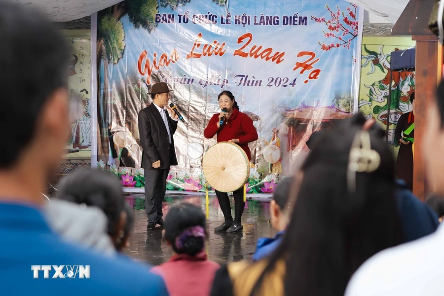 Du khách nhiệt tình tham gia giao lưu Quan họ để đưa lời ca, tiếng hát đến người nghe. (Ảnh: Đoàn Công Vũ/TTXVN phát)