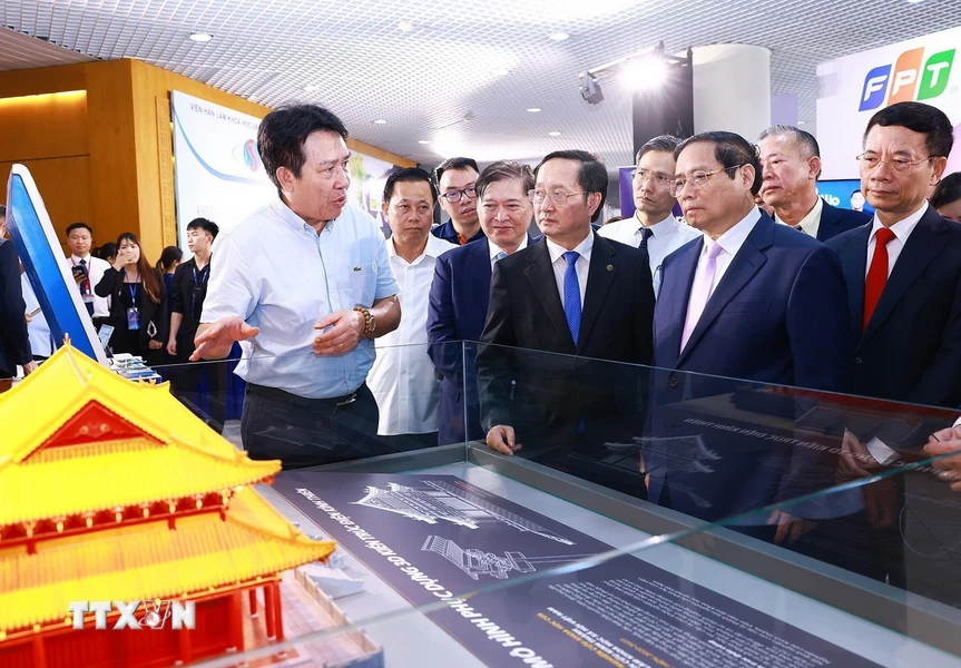 Thủ tướng Phạm Minh Chính tham quan gian trưng bày các sản phẩm ứng dụng khoa học và công nghệ. (Ảnh: Dương Giang/TTXVN)