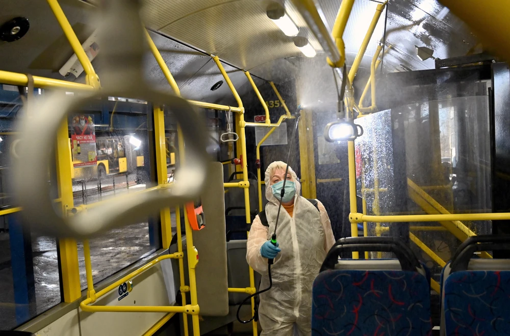 Nhân viên phun thuốc khử trùng trên xe điện nhằm ngăn chặn lây lan của COVID-19 tại Kiev, Ukraine. (Ảnh: AFP/TTXVN)
