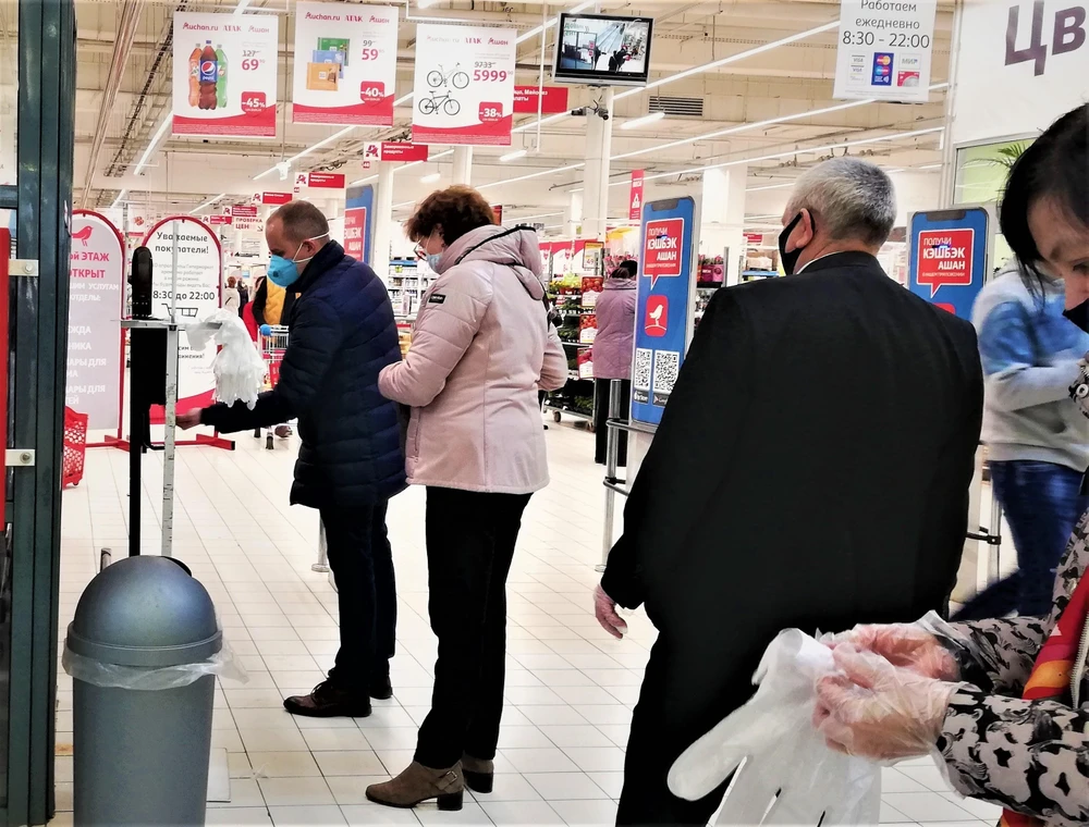 Người dân thủ đô Moskva (Nga) tuân thủ khoảng cách xã hội 2m, xếp hàng đeo găng tay và khử trùng trước khi vào mua hàng. (Ảnh: Duy Trinh/TTXVN)