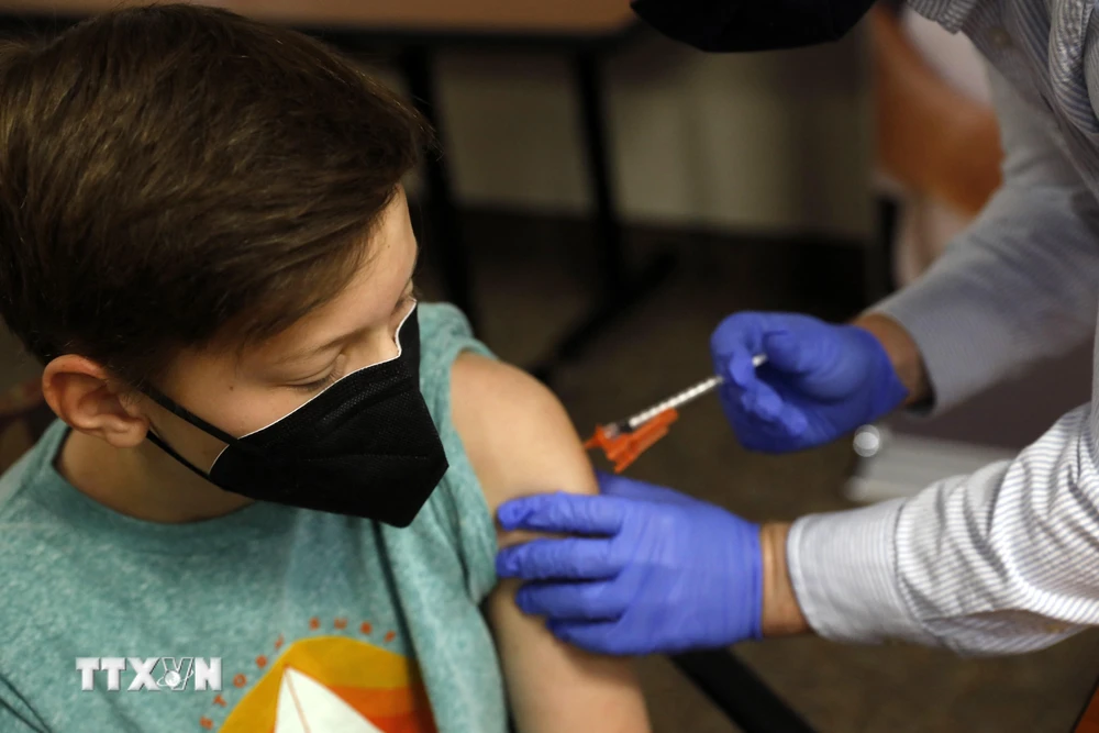 Nhân viên y tế tiêm vaccine ngừa COVID-19 cho trẻ em tại Bloomfield Hills, bang Michigan, Mỹ. (Ảnh: AFP/TTXVN)