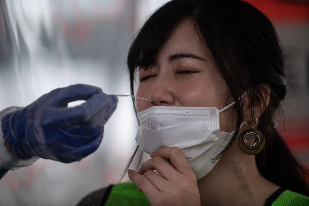 Nhân viên y tế lấy mẫu xét nghiệm COVID-19 tại Fujisawa, tỉnh Kanagawa của Nhật Bản, ngày 27/4 vừa qua. (Ảnh: AFP/TTXVN)