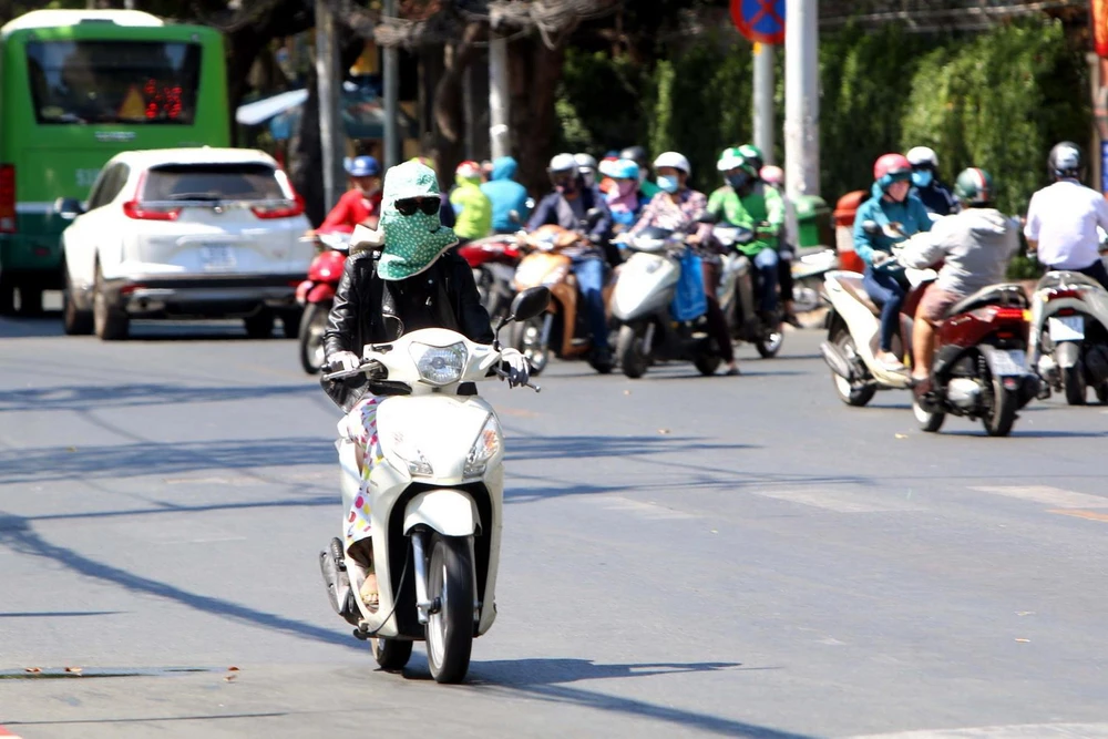 Người dân Thành phố Hồ Chí Minh trùm kín người khi đi ra đường. (Ảnh: Thanh Vũ/TTXVN)