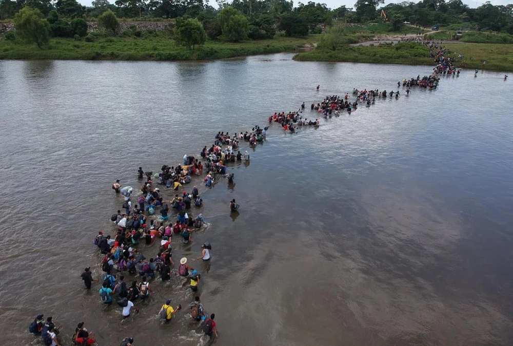 Người di cư băng qua sông Suchiate để tới Mexico, trong hành trình tới Mỹ, ngày 2/11/2018. (Ảnh: AFP/TTXVN)