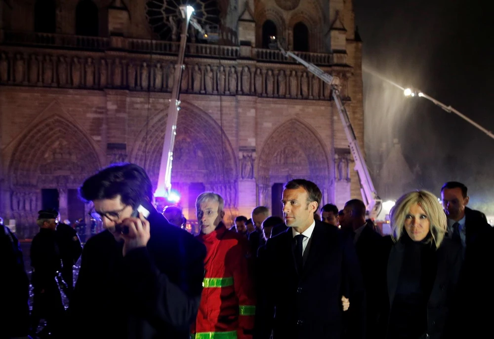 Tổng thống Pháp Emmanuel Macron cùng phu nhân thị sát hiện trường vụ cháy Nhà thờ Đức Bà ở Paris tối 15/4/2019. (Ảnh: AFP/TTXVN)