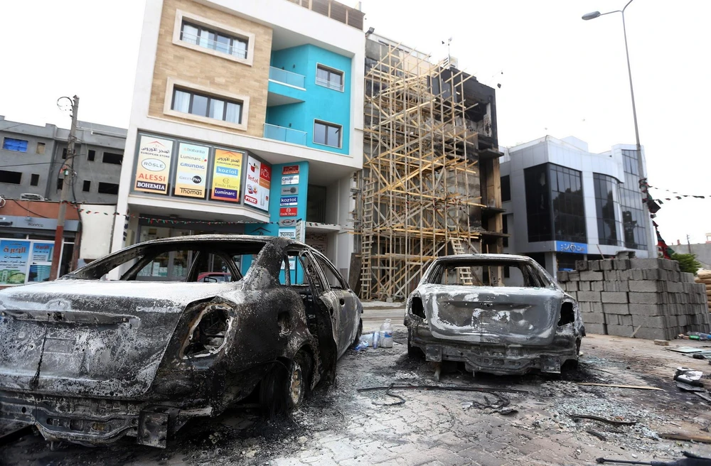 Ô tô bị phá hủy sau một vụ tấn công ở Tripoli, Libya. (Ảnh: AFP/TTXVN)
