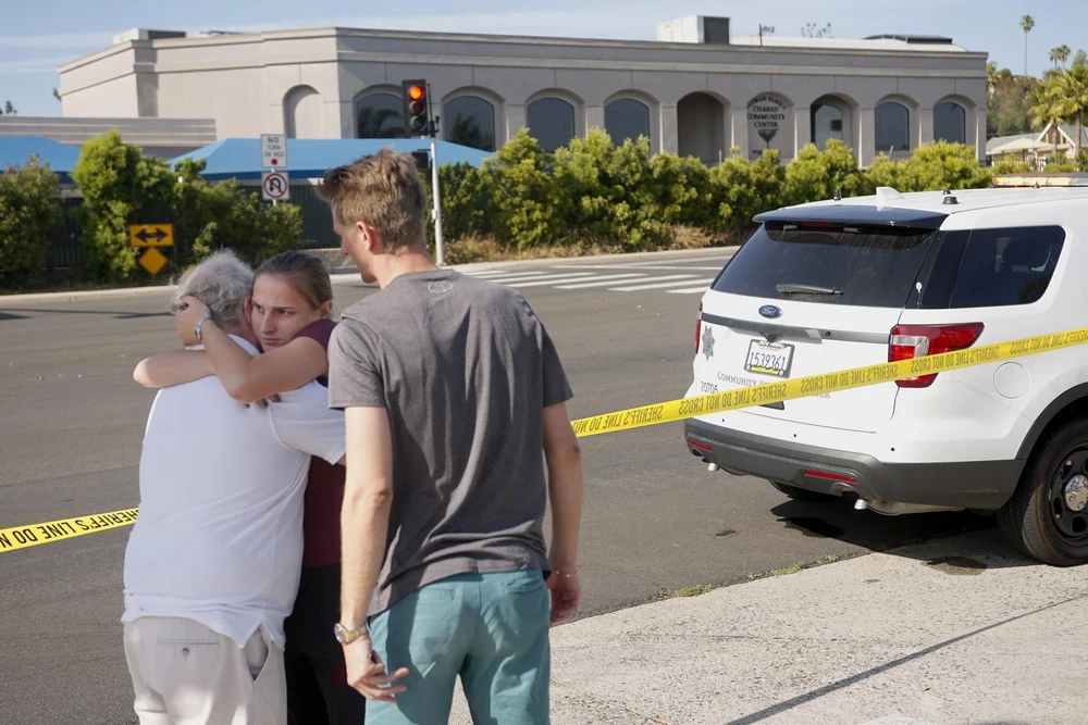 Người dân an ủi nhau sau vụ xả súng tại giáo đường Do Thái ở thị trấn Poway, San Diego, bang California (Mỹ). (Ảnh: AFP/TTXVN)