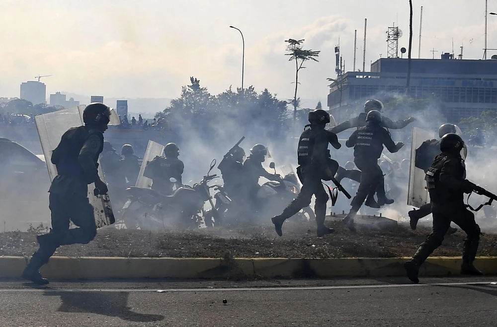 Lực lượng trung thành với Tổng thống Venezuela Nicolas Maduro ngăn các tay súng thuộc nhóm binh sỹ ủng hộ thủ lĩnh đối lập Juan Guaido nổi dậy. (Ảnh: AFP/TTXVN)
