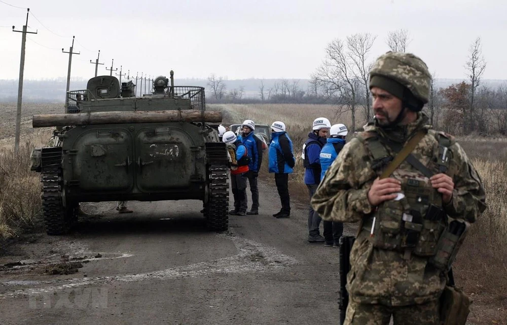 Các quan sát viên OSCE giám sát quá trình rút quân của các lực lượng Ukraine ở gần làng Bogdanivka thuộc vùng Donetsk. (Ảnh: AFP/TTXVN)