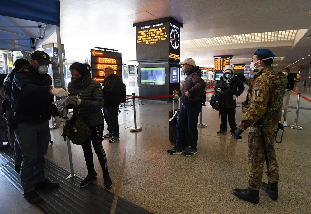 Cảnh sát kiểm tra giấy tờ của hành khách tại nhà ga tàu hỏa Roma Termini ở Rome, Italy ngày 23/3/2020, trong bối cảnh dịch COVID-19 lan rộng. (Ảnh: THX/TTXVN)