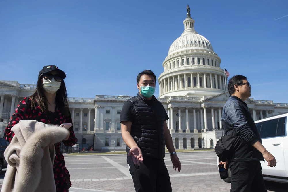 Người dân đeo khẩu trang để phòng tránh lây nhiễm COVID-19, bên ngoài tòa nhà Quốc hội Mỹ ở Washington, DC, ngày 9/3/2020. (Ảnh: AFP/TTXVN)