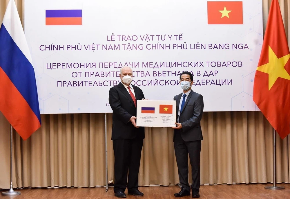 Thứ trưởng Ngoại giao Tô Anh Dũng trao vật tư y tế cho Đại sứ Liên bang Nga tại Việt Nam Konstantin Vnukov. (Ảnh: Dương Giang/TTXVN)