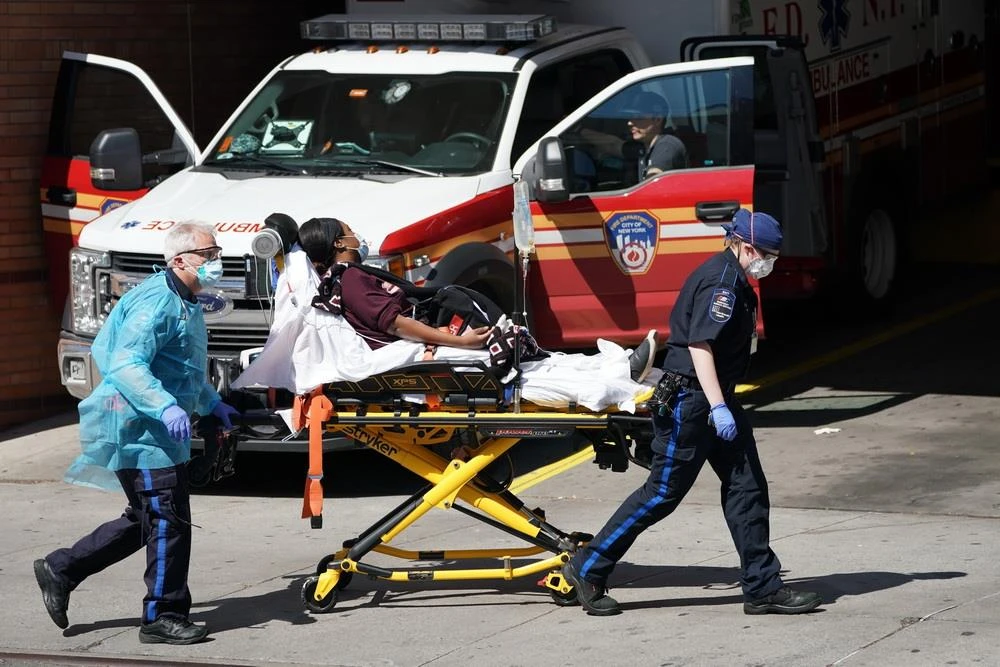 Nhân viên y tế chuyển bệnh nhân mắc COVID-19 từ xe cứu thương vào một bệnh viện ở New York, Mỹ ngày 6/4/2020. (Ảnh: AFP/TTXVN)