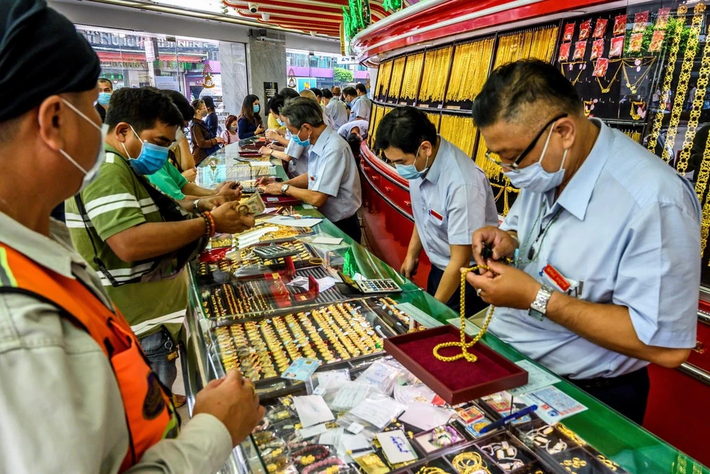 Người dân mua bán vàng tại một cửa hàng ở Bangkok, Thái Lan ngày 15/4/2020. (Ảnh: AFP/TTXVN)
