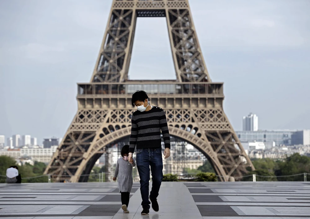 Trẻ em thăm Tháp Eiffel ở Paris, Pháp trong bối cảnh dịch COVID-19 bùng phát mạnh, ngày 20/4/2020. (Ảnh: AFP/TTXVN)