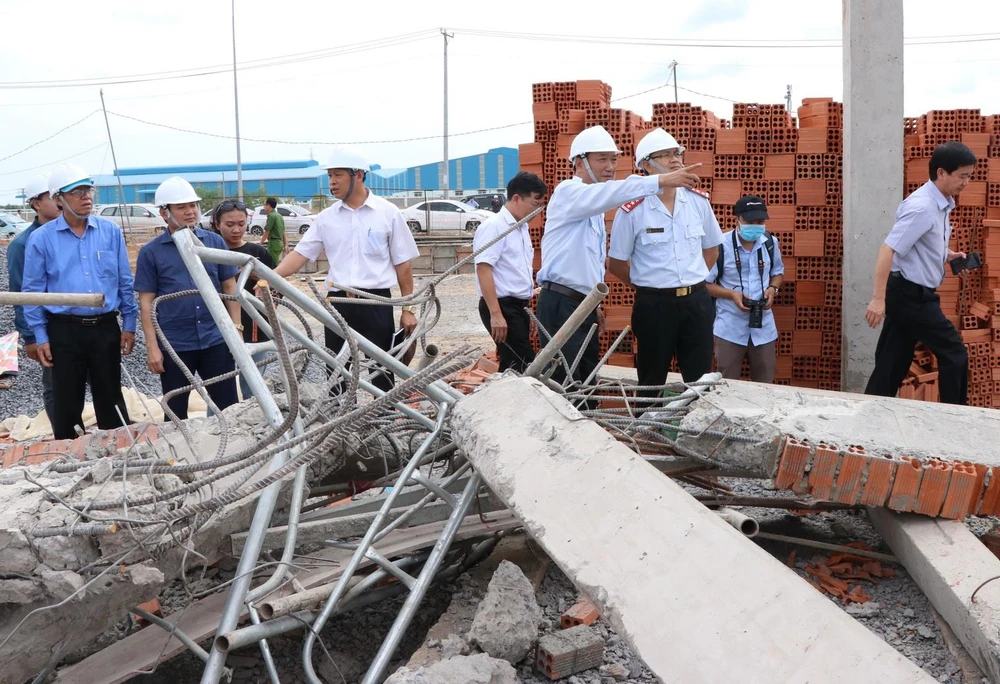 Thứ trưởng Lê Quang Hùng cùng đoàn công tác liên bộ kiểm tra hiện trường sập công trình xây dựng. (Ảnh: Sỹ Tuyên/TTXVN)