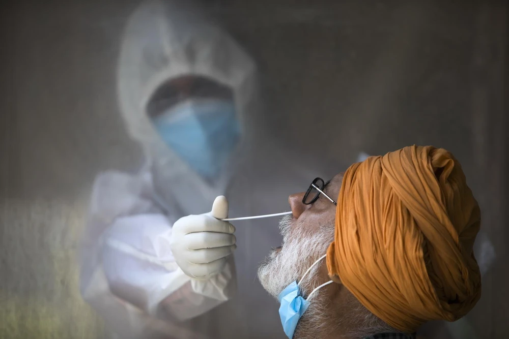 Nhân viên y tế lấy mẫu xét nghiệm COVID-19 tại New Delhi, Ấn Độ, ngày 17/6/2020. (Ảnh: AFP/TTXVN)